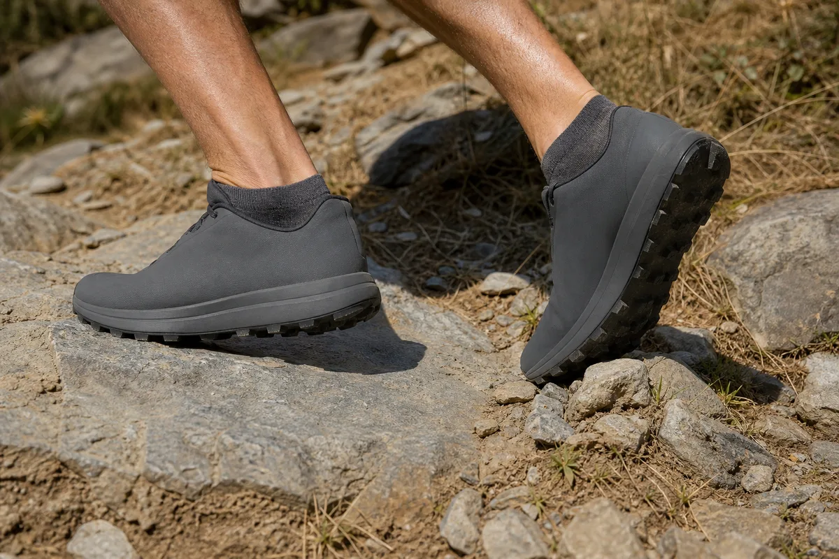 Chaussures de trail en appui sur un sentier caillouteux en montée